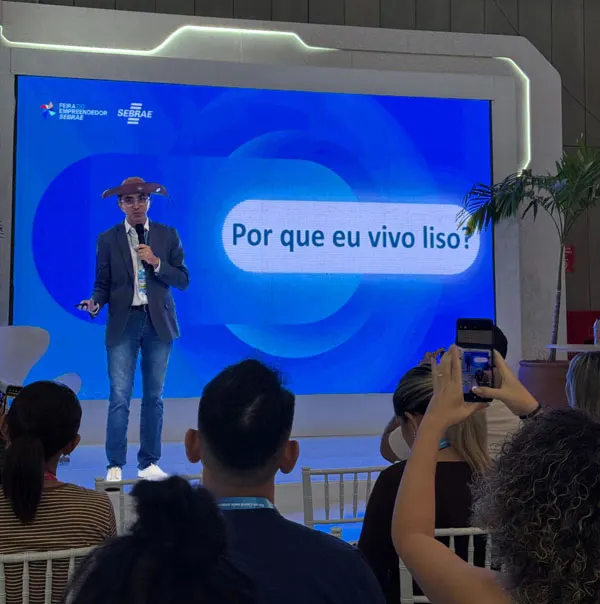 Marco Holanda no palco com o slide 'Por que eu vivo liso?'